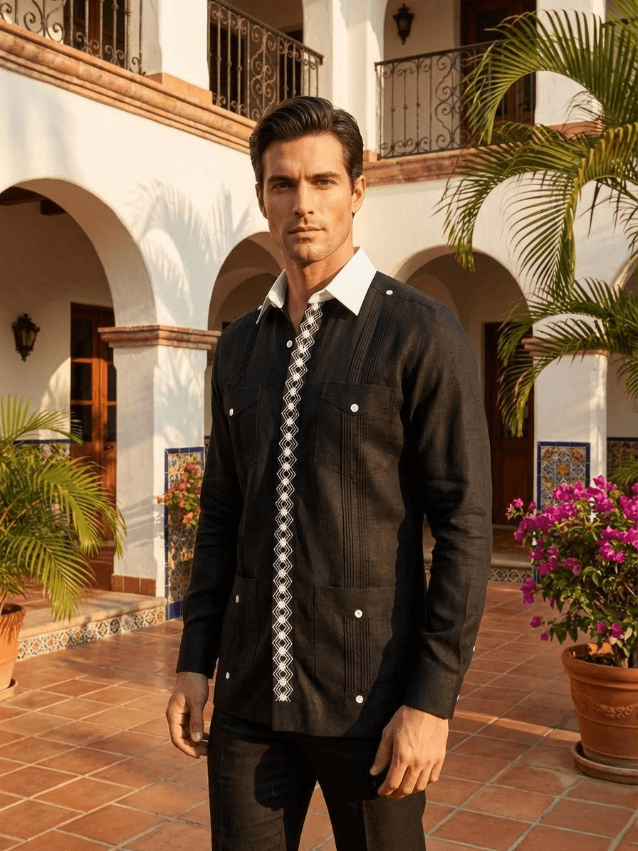 Camisa guayabera negra de manga larga con una franja central de bordado geométrico blanco y cuatro bolsillos con botones blancos, presentada en un maniquí.