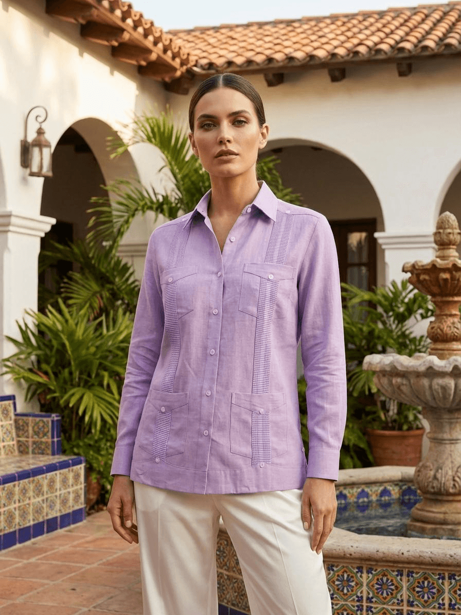 Camisa guayabera de manga larga en color lila con cuatro bolsillos frontales, pliegues verticales tradicionales y botones blancos, presentada en un maniquí.